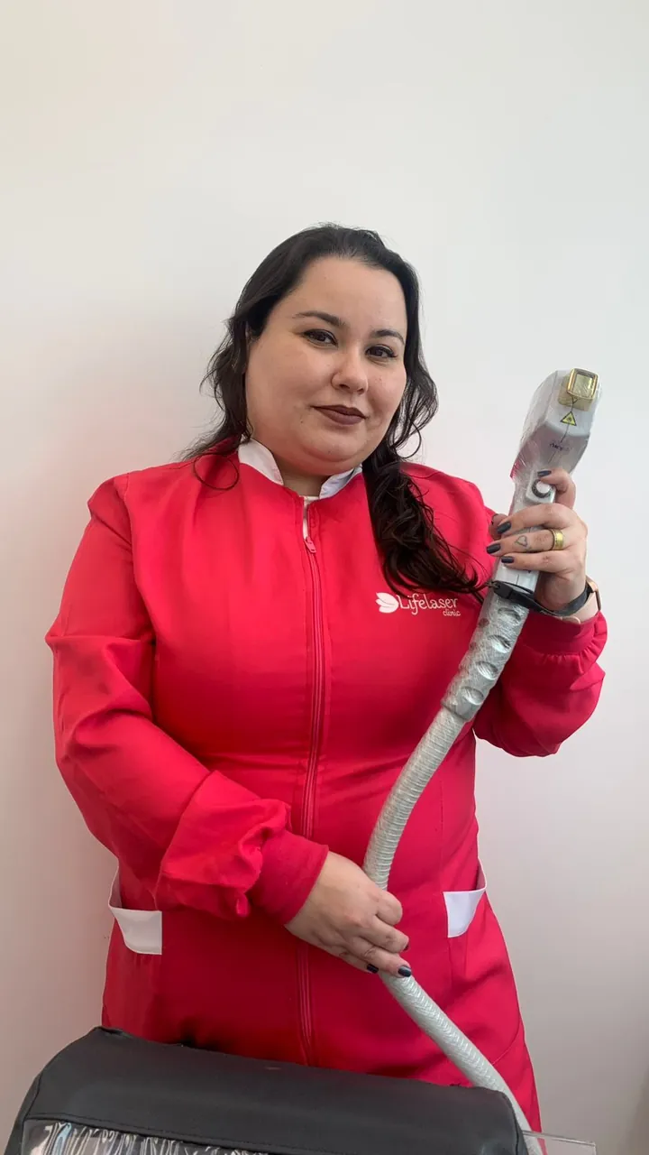 Técnica da Lifelaser, de uniforme, segurando a ponteira do aparelho de LED